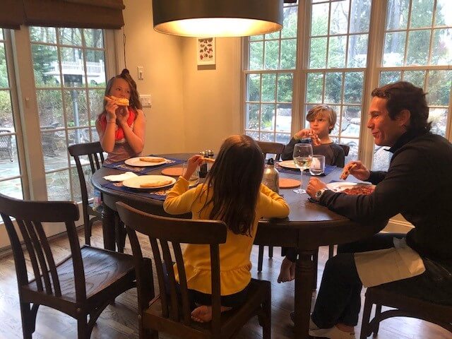 Family eating pizza at kitchen table